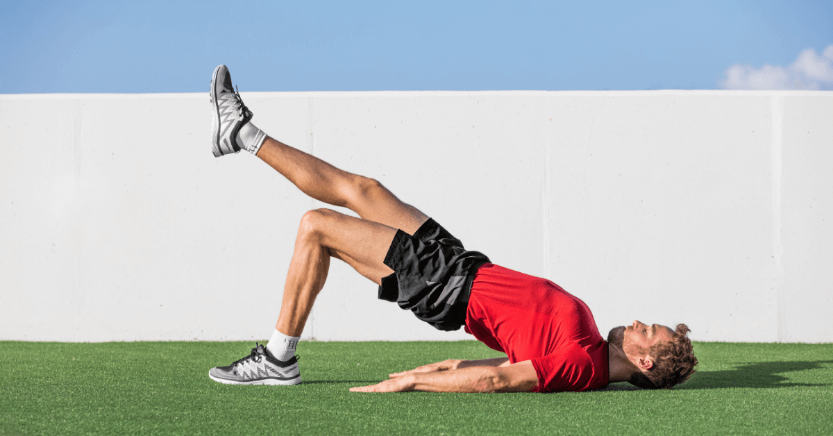 Man outside on grass doing a yoga pose